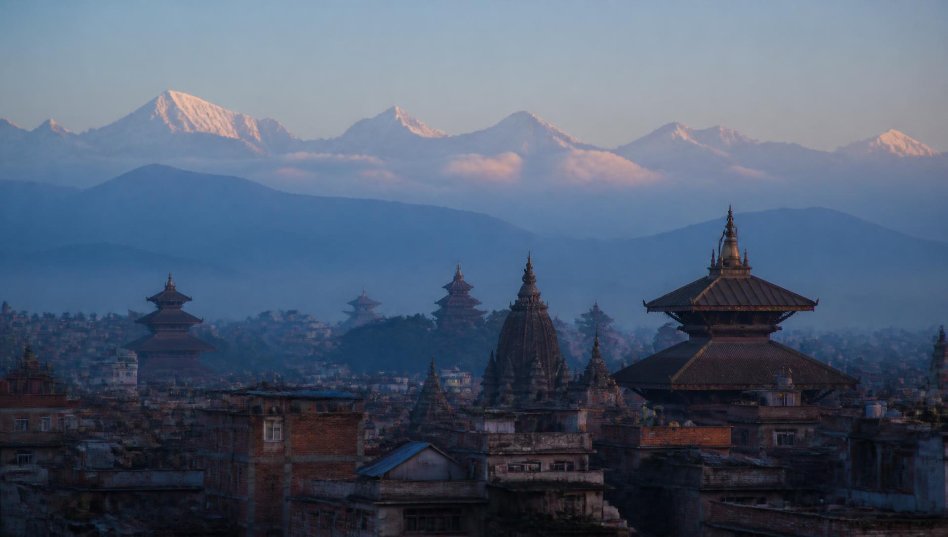Kathmandu valley rooftops at dawn with Himalayan peaks behind